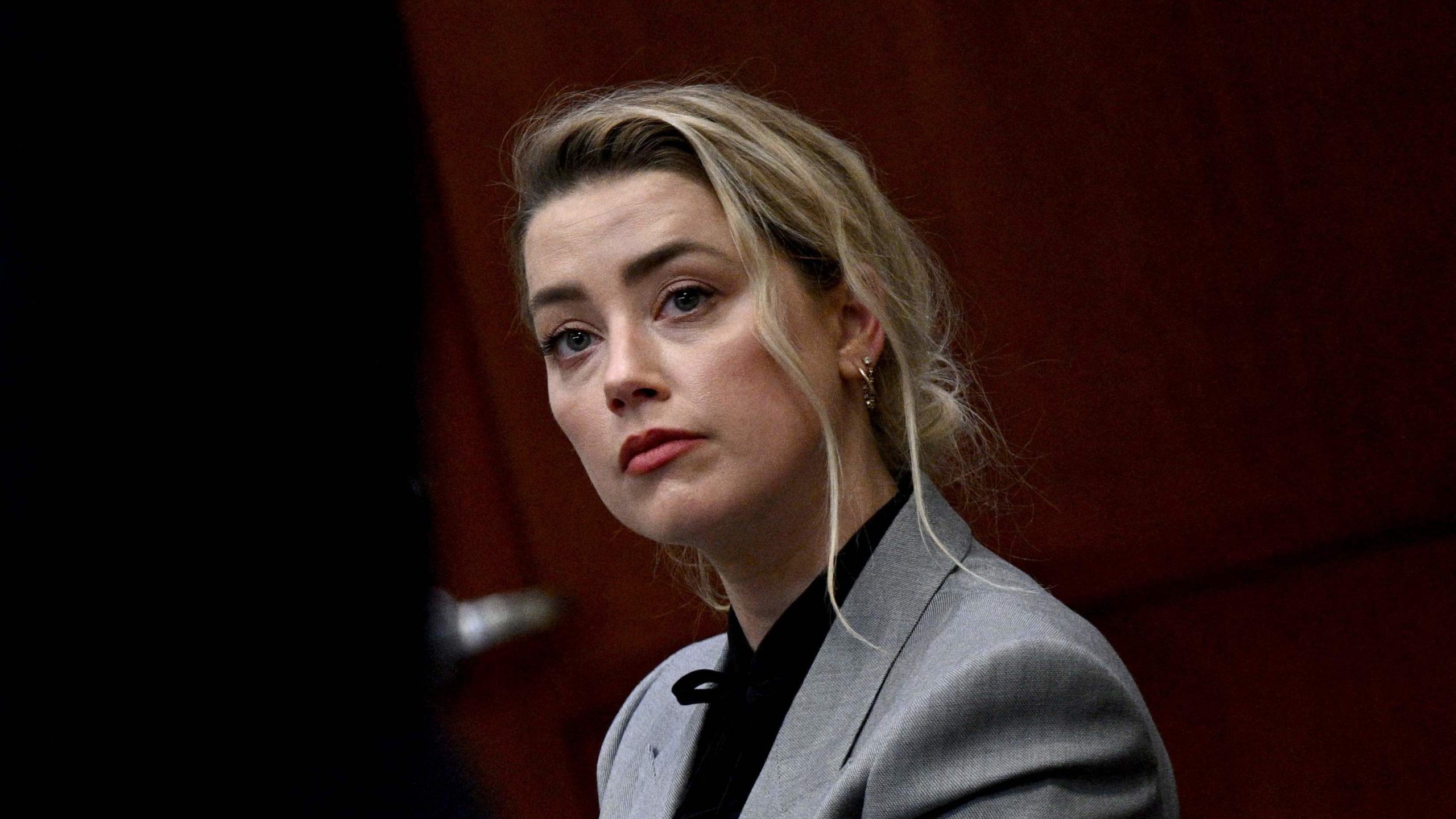 US actress Amber Heard (R) listens during the $50 million Depp vs Heard defamation trial at the Fairfax County Circuit Court in Fairfax, Virginia, on April 12, 2022. - Allegations of domestic abuse levelled against Johnny Depp by Amber Heard have had a "devastating" impact on his career, his lawyers said Tuesday at the opening of the actor's defamation case against his former wife. (Photo by BRENDAN SMIALOWSKI / POOL / AFP) (Photo by BRENDAN SMIALOWSKI/POOL/AFP via Getty Images)